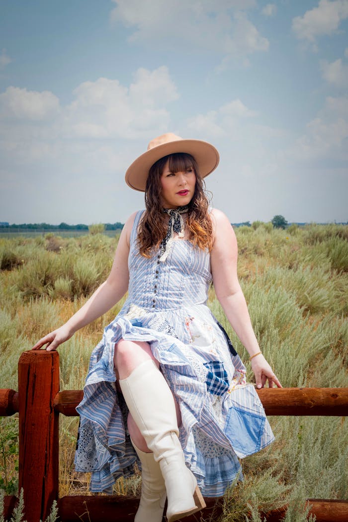 Services-03 Stylish woman in western attire poses outdoors, showcasing modern cowgirl fashion.